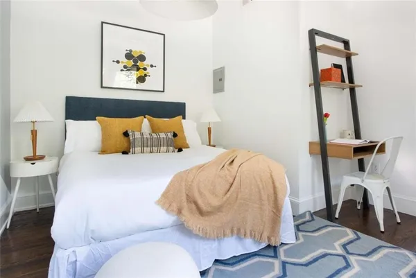 a bedroom with a bed and wooden floor