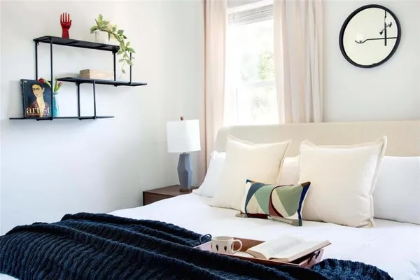 a bedroom with a bed and a painting on the wall