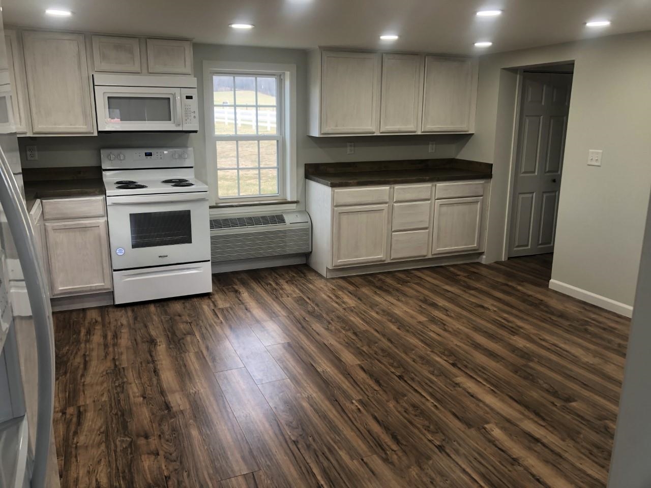 7057 Briery Branch Road Dayton, VA 22821 - Photo 14 of 29 a kitchen with wooden floors and white stainless steel appliances