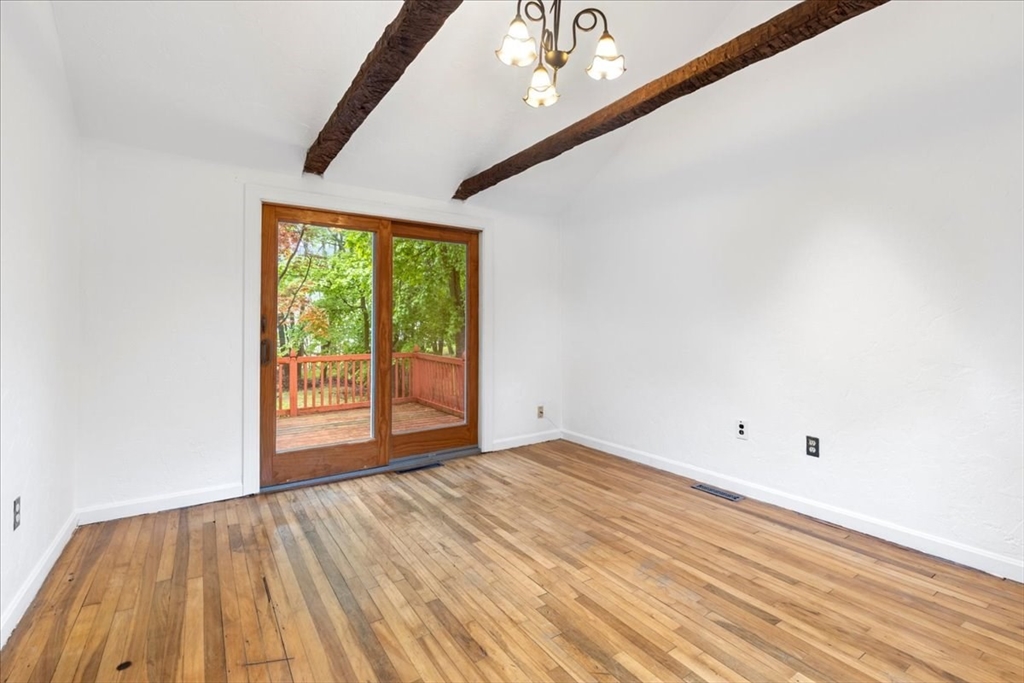 203 High Street, Unit 203 Hingham, MA 02043 - Photo 14 of 42 a view of an empty room with wooden floor and a window