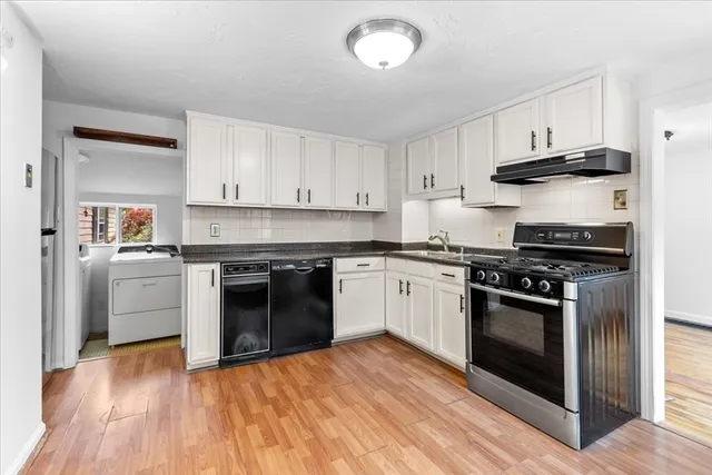 a kitchen with granite countertop white cabinets and stainless steel appliances