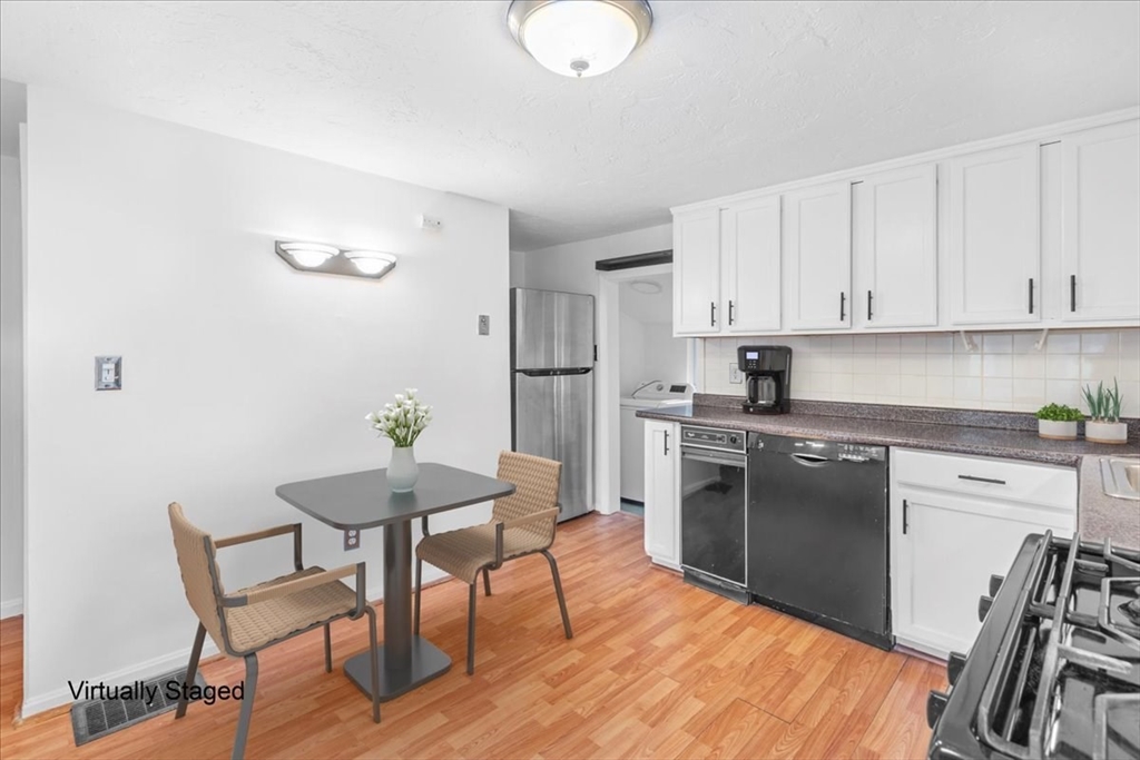 203 High Street, Unit 203 Hingham, MA 02043 - Photo 18 of 42 a kitchen with granite countertop white cabinets and stainless steel appliances