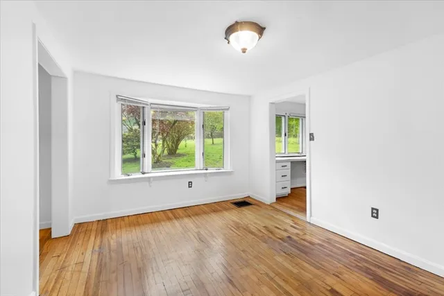 a bedroom with a bed couches and potted plant on the dresser