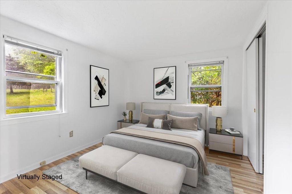 203 High Street, Unit 203 Hingham, MA 02043 - Photo 32 of 42 a bedroom with a bed and wooden floor