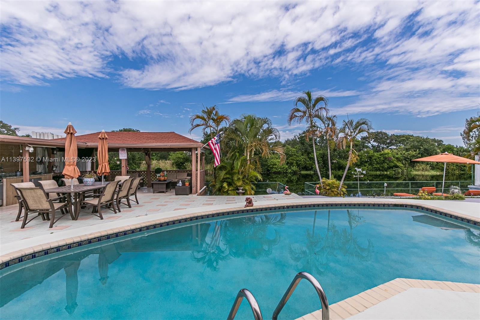 3820 Northwest 7th Avenue Deerfield Beach, FL 33064 - Photo 17 of 37 a view of a swimming pool with lawn chairs and plants