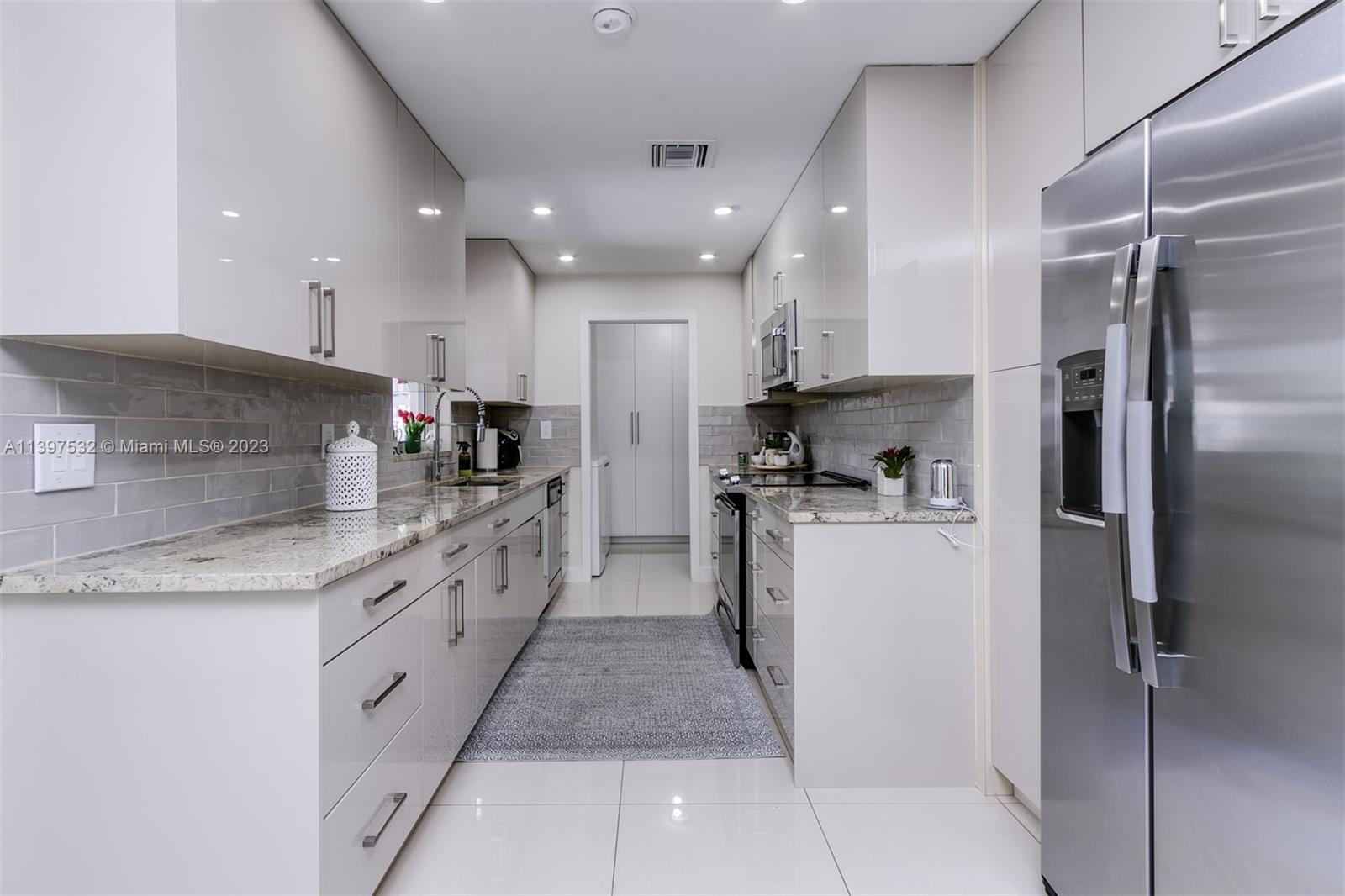 3820 Northwest 7th Avenue Deerfield Beach, FL 33064 - Photo 20 of 37 a large kitchen with stainless steel appliances kitchen island granite countertop a refrigerator and a sink