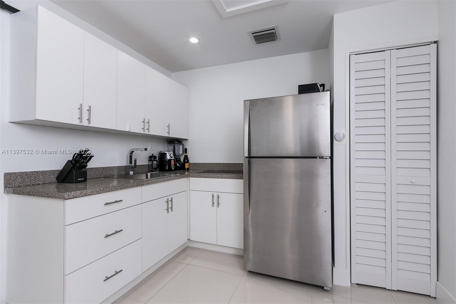 3820 Northwest 7th Avenue Deerfield Beach, FL 33064 - Photo 29 of 37 a kitchen with stainless steel appliances granite countertop white refrigerator and cabinets