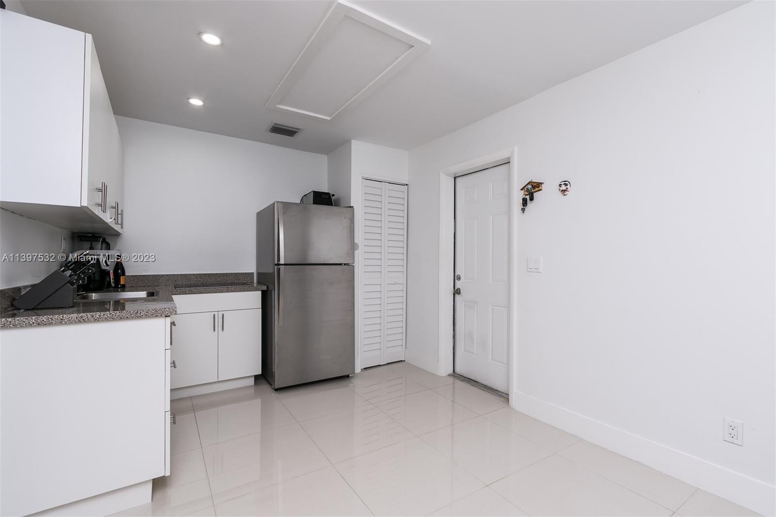 3820 Northwest 7th Avenue Deerfield Beach, FL 33064 - Photo 30 of 37 a kitchen with a refrigerator sink and cabinets