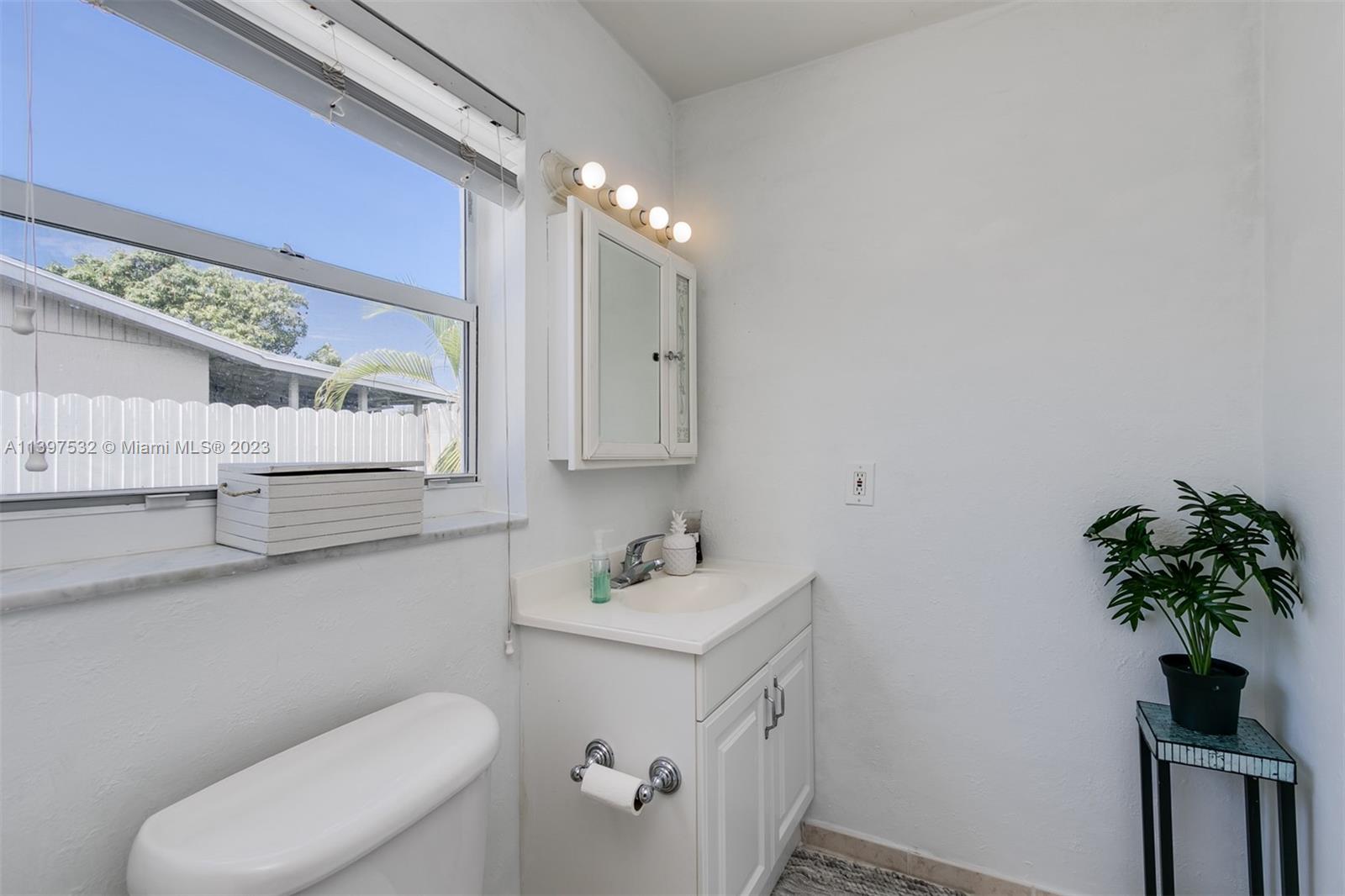 3820 Northwest 7th Avenue Deerfield Beach, FL 33064 - Photo 33 of 37 a bathroom with a toilet sink and mirror