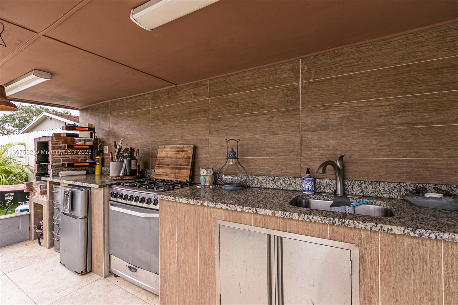 3820 Northwest 7th Avenue Deerfield Beach, FL 33064 - Photo 7 of 37 a kitchen with stainless steel appliances granite countertop a sink stove and cabinets
