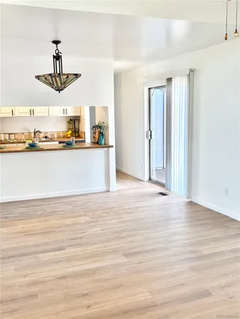 a living room with stainless steel appliances kitchen island granite countertop a sink and cabinets