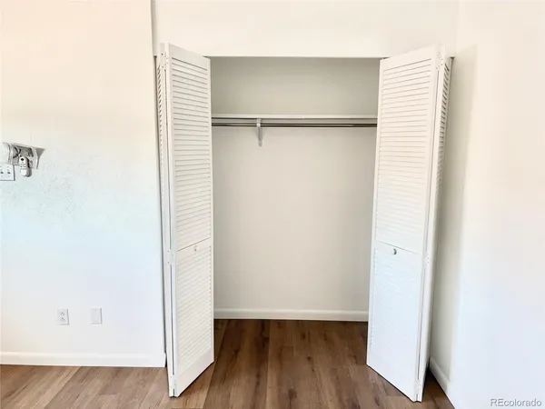 an empty room with wooden floor and a window