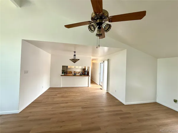 a view of empty room with wooden floor and fireplace