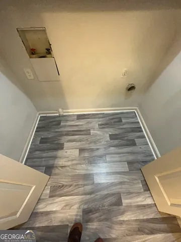a view of a hallway with wooden floor and a livingroom