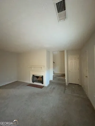 an empty room with a fireplace and window
