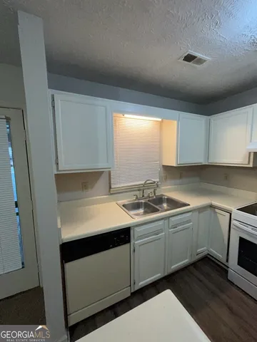 a kitchen with a refrigerator and a stove top oven