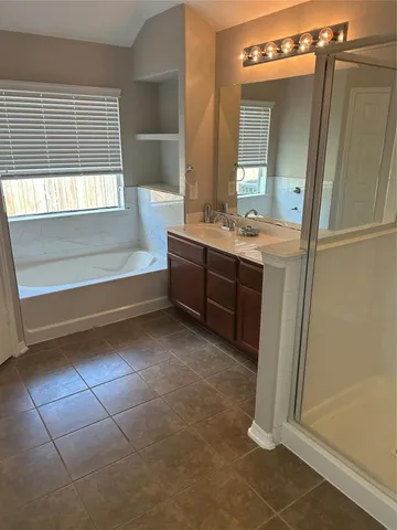 a bathroom with a bathtub sink and mirror