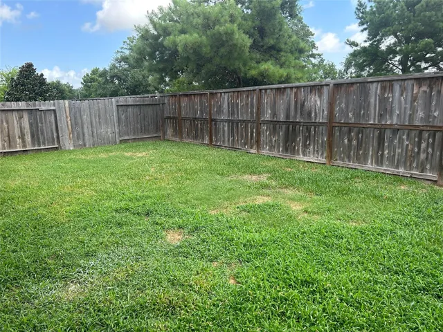a view of a backyard with wooden fence