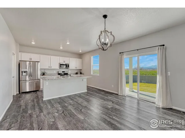 a view of large open kitchen with refrigerator and window