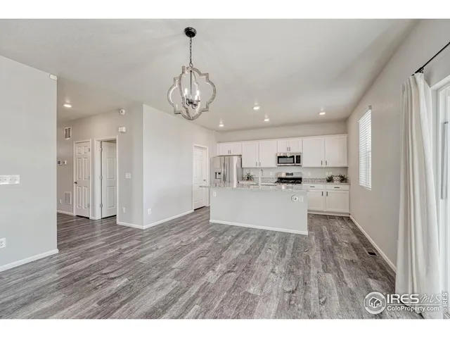 a kitchen with granite countertop a sink a stove cabinets and wooden floor