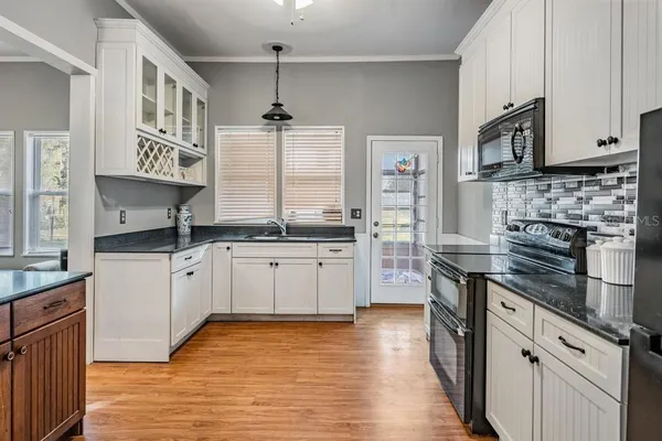 a kitchen with stainless steel appliances granite countertop a stove and cabinets