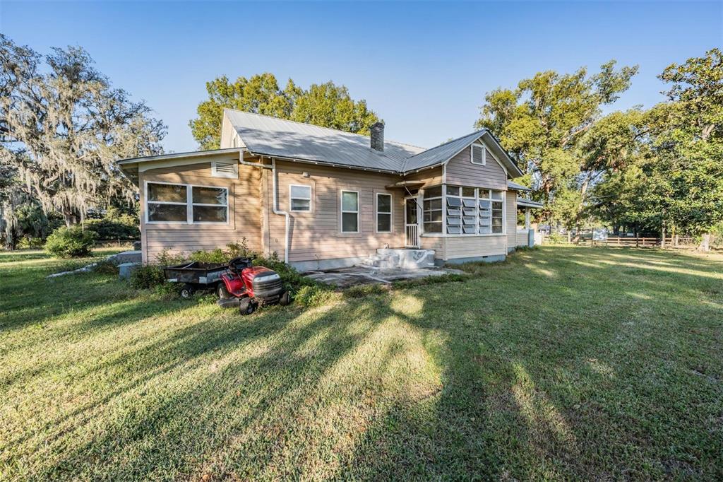 7207 Elwood Road Zephyrhills, FL 33540 - Photo 23 of 23 a view of a house with a big yard and potted plants