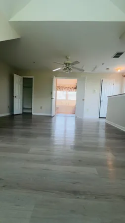 a view of empty room with wooden floor