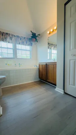 an empty room with windows and cabinet