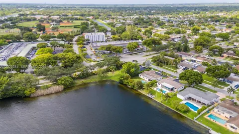 an aerial view of residential houses with outdoor space and trees