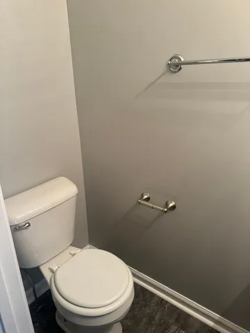 a white toilet sitting next to a shower