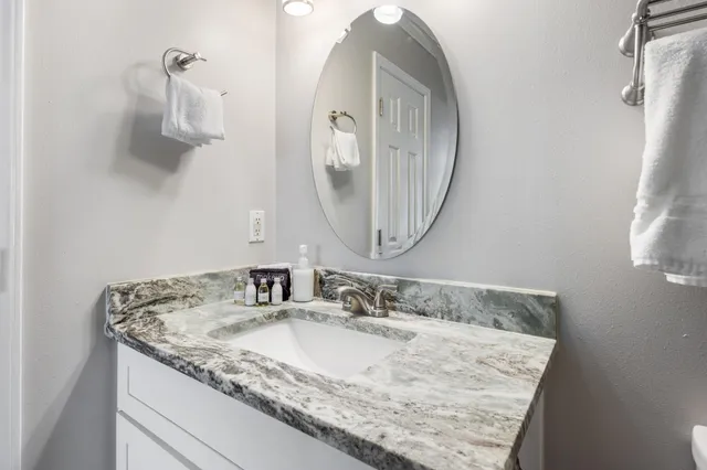 a bathroom with a granite countertop shower a toilet and a sink