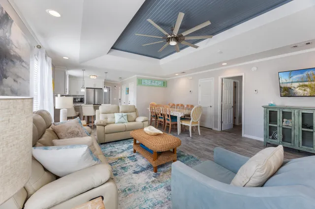 a living room with furniture and a view of kitchen
