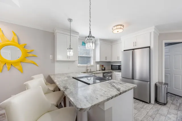 a kitchen with stainless steel appliances granite countertop a sink refrigerator and cabinets