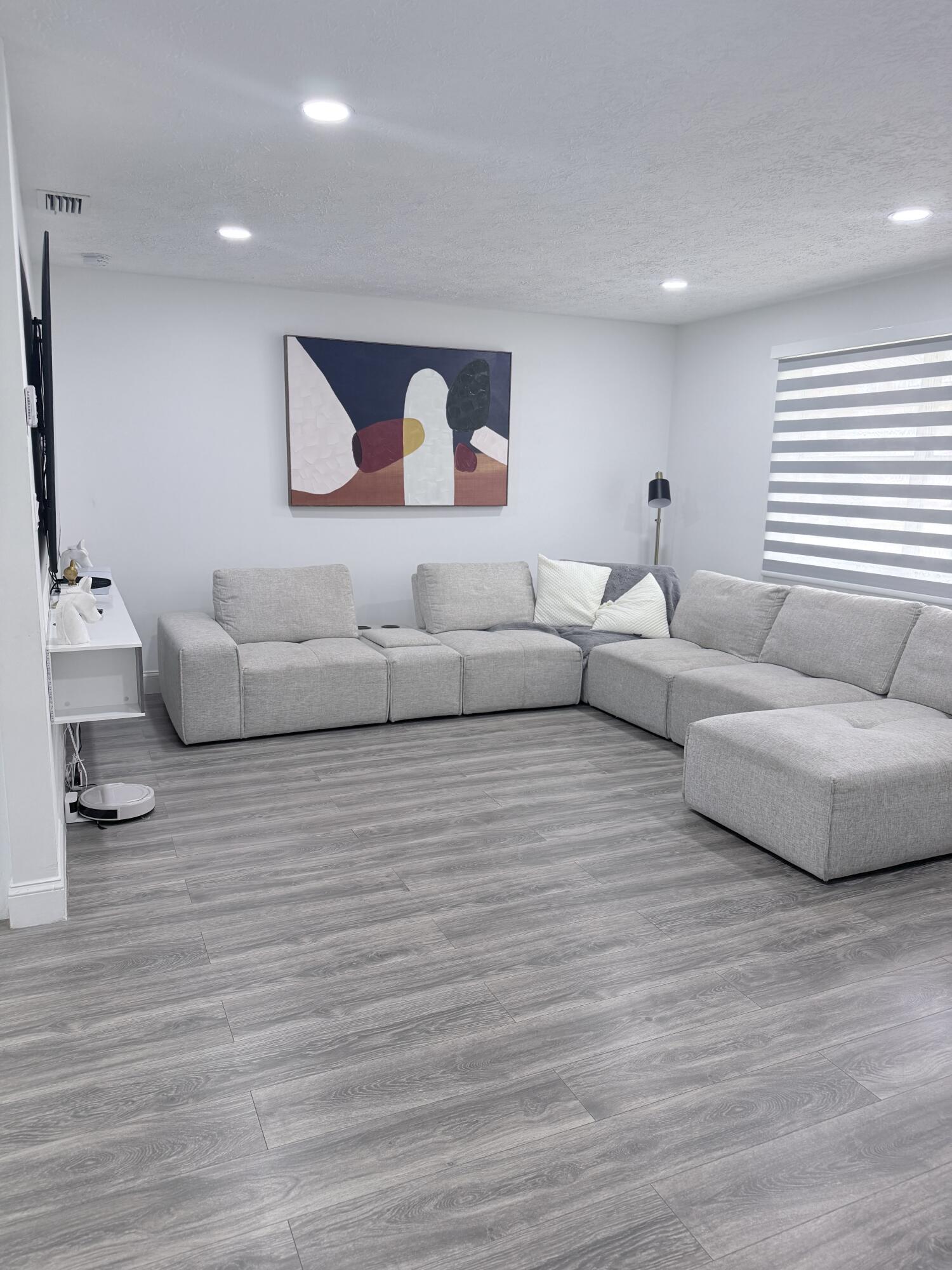 302 Southwest Whitmore Drive Port St. Lucie, FL 34984 - Photo 2 of 21 a living room with furniture and a wooden floor