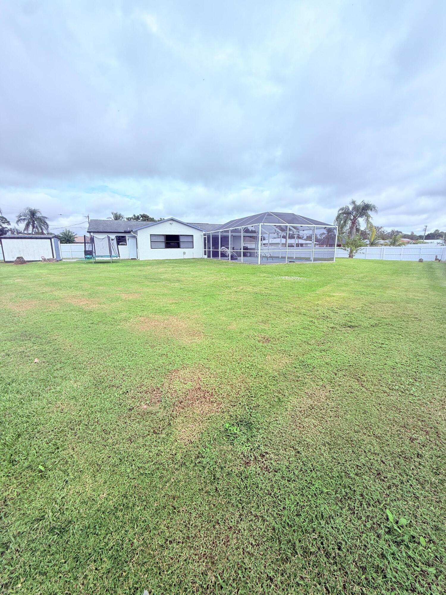 302 Southwest Whitmore Drive Port St. Lucie, FL 34984 - Photo 21 of 21 a view of yard with lawn chairs and large trees