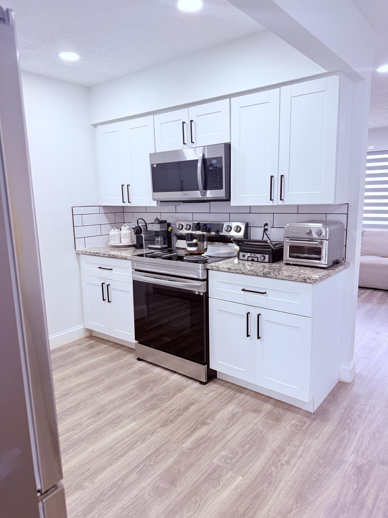 302 Southwest Whitmore Drive Port St. Lucie, FL 34984 - Photo 7 of 21 a kitchen with stainless steel appliances a stove top oven and sink