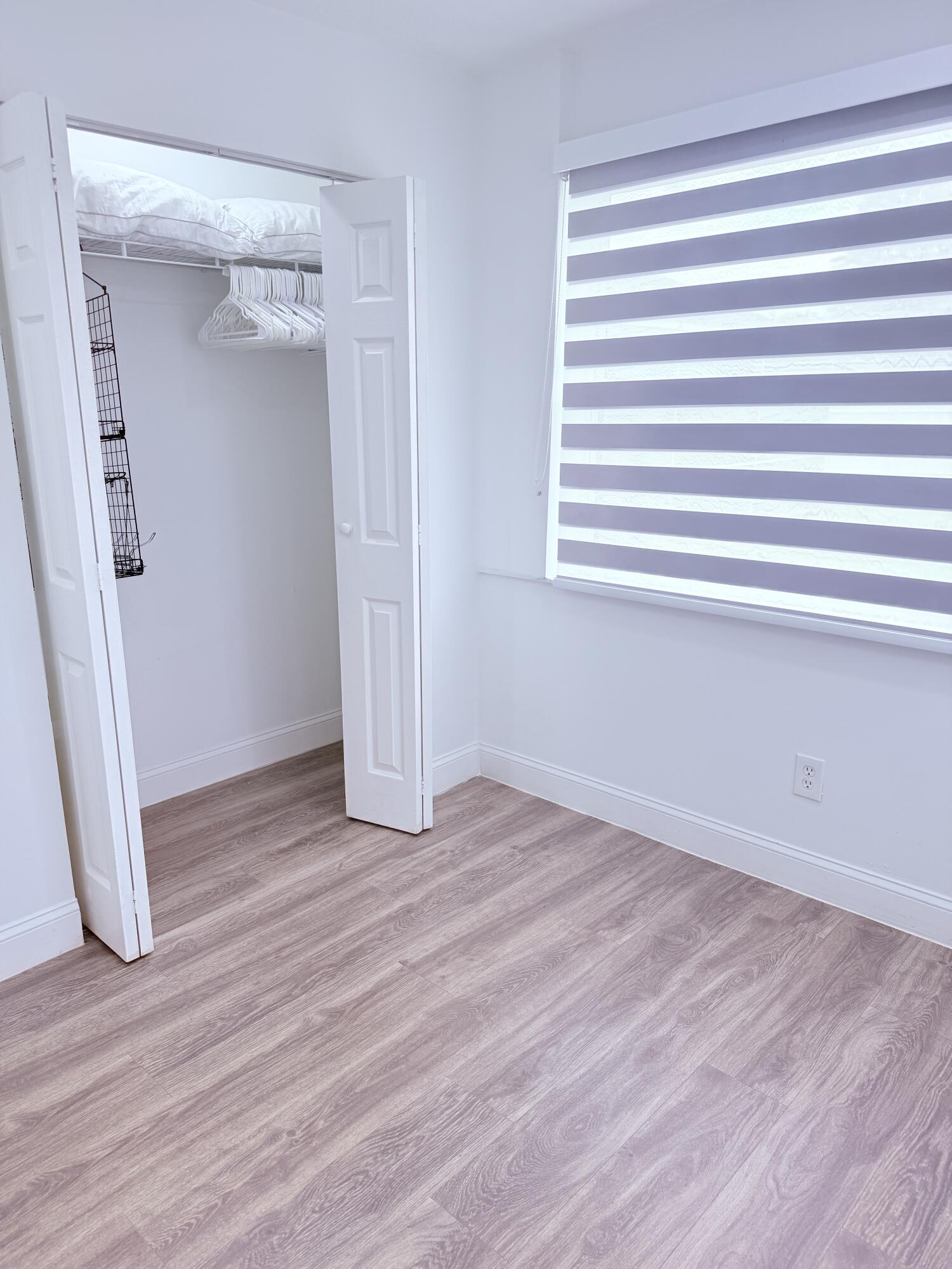 302 Southwest Whitmore Drive Port St. Lucie, FL 34984 - Photo 10 of 21 a view of empty room with wooden floor and fan