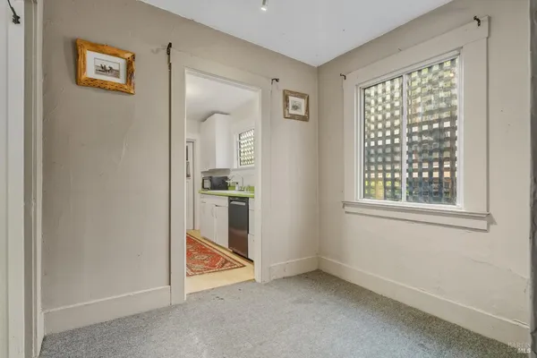 a view of a kitchen with refrigerator and window