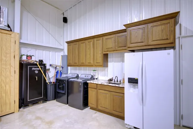 a kitchen with stainless steel appliances granite countertop a refrigerator and a stove top oven