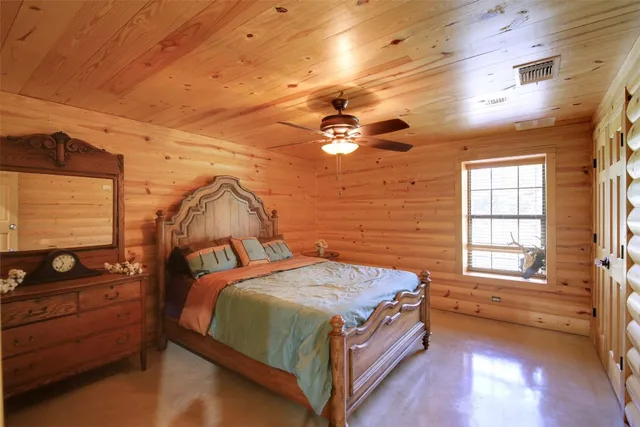a bedroom with a bed and a dresser next to a window