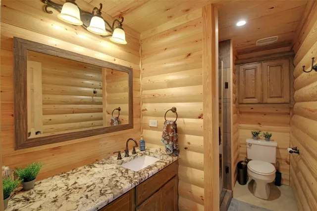 a bathroom with a granite countertop sink toilet and shower
