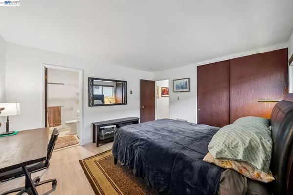 a bedroom with a bed and wooden floor