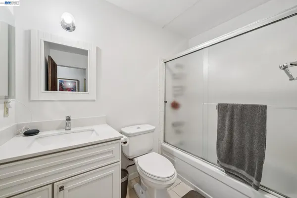 a bathroom with a sink a mirror a toilet and shower