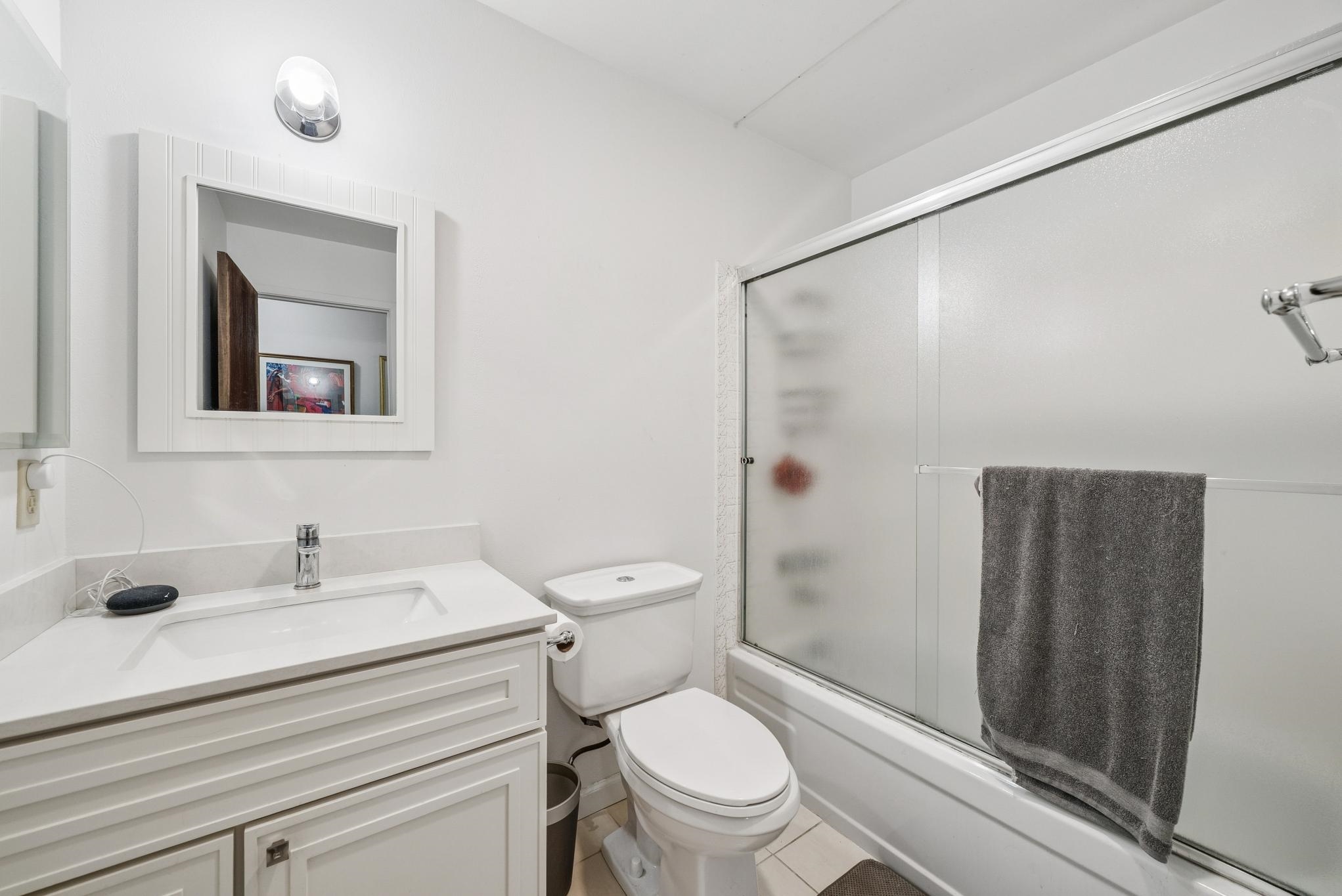 1401 Cottage Street, Unit D Alameda, CA 94501 - Photo 19 of 25 a bathroom with a sink a mirror a toilet and shower