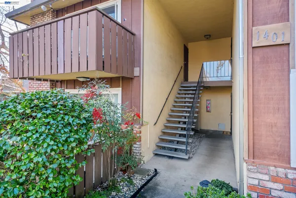a view of a house with wooden stairs and flower plants