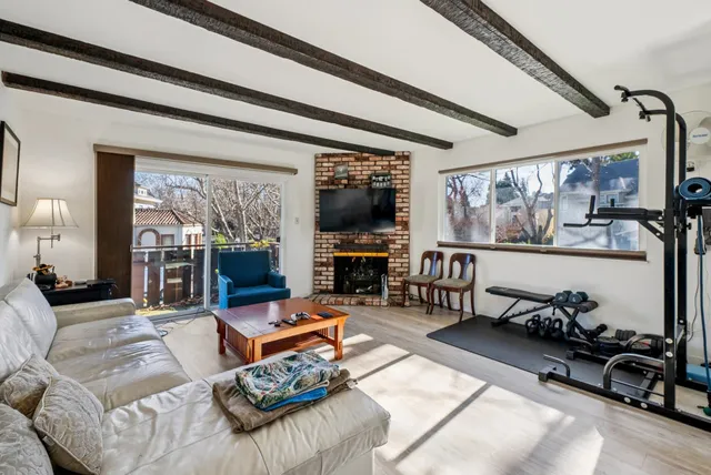 a living room with furniture gym equipment and a large window