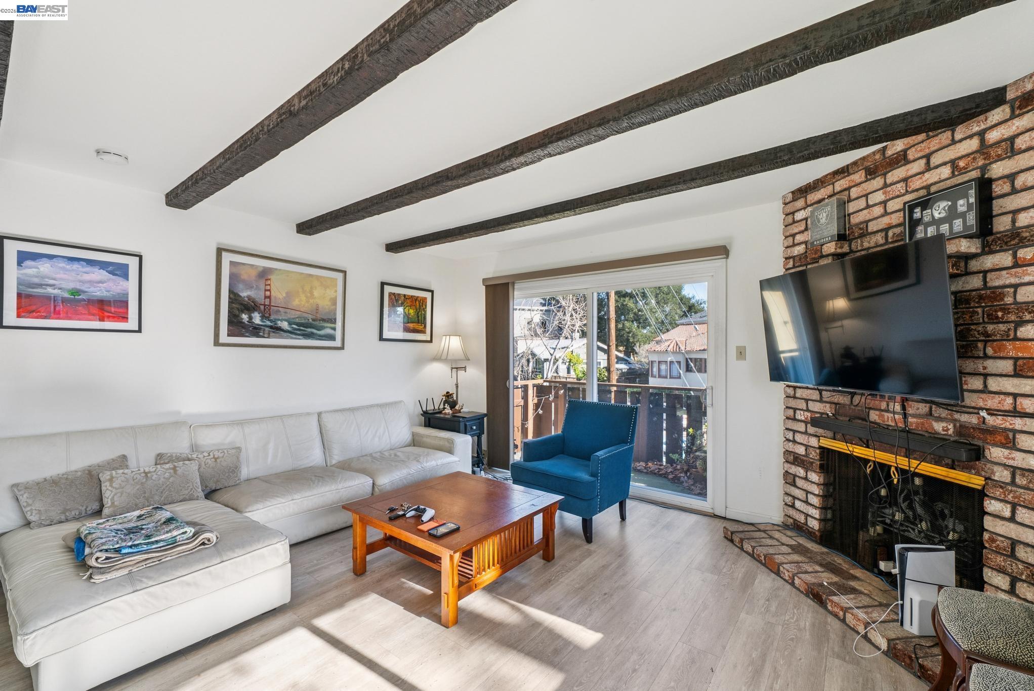 1401 Cottage Street, Unit D Alameda, CA 94501 - Photo 7 of 25 a living room with furniture a flat screen tv and a floor to ceiling window