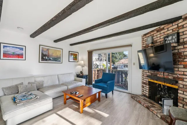 a living room with furniture a flat screen tv and a floor to ceiling window