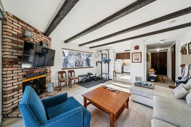 a living room with furniture a flat screen tv and a floor to ceiling window