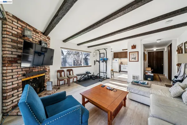 a living room with furniture a flat screen tv and a floor to ceiling window